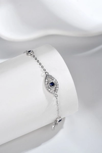 Macro shot of silver Evil Eye bracelet featuring blue center stone and white zircons