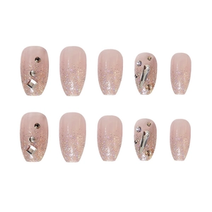 Macro detail of nude gradient press-on nails with sparkling glitter and rhinestones