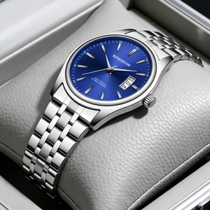 Detail of silver steel watch with blue dial and calendar feature on beige cushion