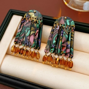 Detail of bohemian tassel earrings with colorful acrylic tiles and amber beads in a gift box