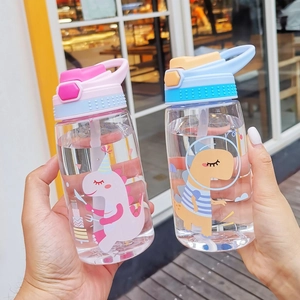Close-up of children's plastic straw cups featuring cute dinosaur and space patterns
