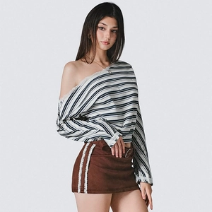 Detail showing lace trim on striped off-shoulder top and brown suede mini skirt outfit