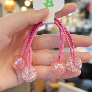 Detailed view of pink double-strand hair tie with four decorative candy glitter balls