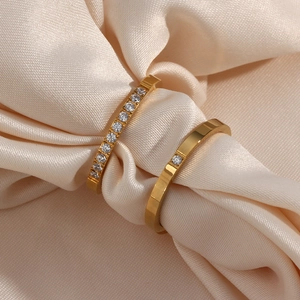 Bagues élégantes en acier plaqué or 18 carats avec zircons sur soie couleur champagne