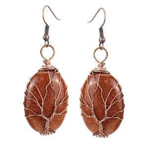 Close-up of handmade tree of life wire-wrapped earrings with brown goldstone