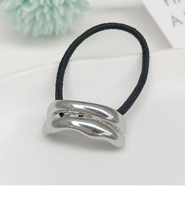 Close-up of a black elastic ponytail holder featuring a wavy silver polished metal buckle