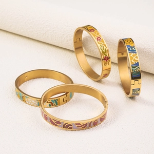 Detail of four golden 18K vacuum plated enamel bangles with colorful floral and geometric patterns