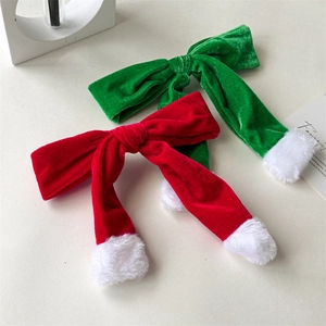 Macro view of Christmas velvet hair clips with red and green bows and white fur trim