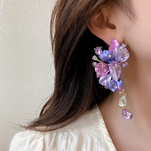 Macro shot of vintage purple floral tassel earrings with rhinestones on model