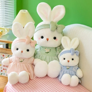 Three plush rabbits in colorful flower dresses on pink plaid background for gifts