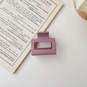 Detail view of square matte hair claw in lotus pink on a minimalist white surface