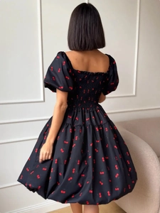 Detail of the smocked elastic back and cherry print on this square neck puff sleeve dress