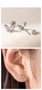 Macro view of titanium steel butterfly screw-back stud earrings with white zirconia