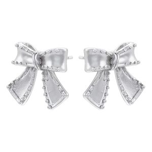 Macro detail of silver bow earrings with textured grainy finish and polished metal shine