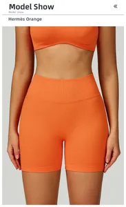 Dettaglio dei pantaloncini yoga arancioni senza cuciture con vita alta a coste elasticizzata