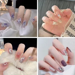 Detail showing four styles of press-on nails with butterfly and heart diamond charms