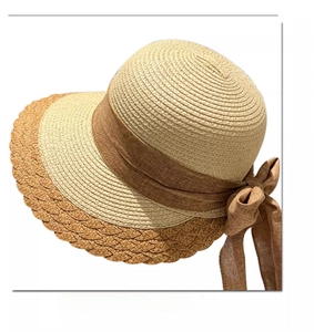 Close-up of wavy brim edges and brown chiffon ribbon bow on straw sun hat