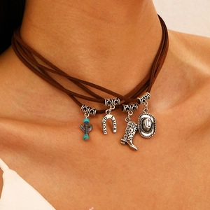 Detail of layered brown suede necklace featuring silver cactus, boot, and hat charms