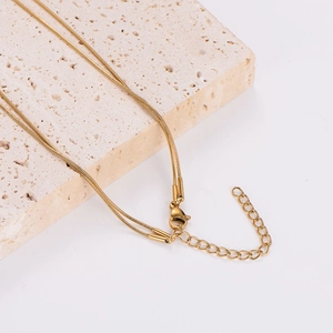Detail of gold double-layer snake chain necklace showing lobster clasp and extender