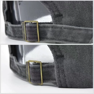 Detail of adjustable metal buckle on dark grey washed cotton baseball cap with strap back