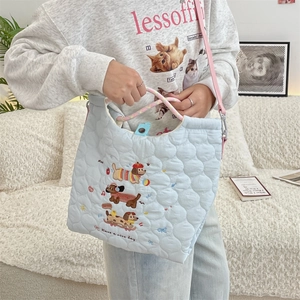 Detail of light blue quilted tote bag with cute puppy embroidery and pink strap