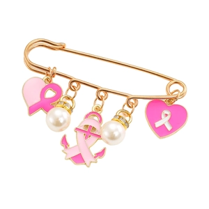 Détail d'une broche dorée avec cœurs à ruban rose, perles et un pendentif ancre