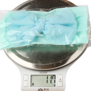 Detailed view showing the 11.7g weight of a blue nylon baby headband on a scale