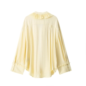 Detail of cream yellow long sleeve blouse featuring pleated collar and pearl buttons