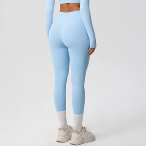 Detail view of high-waist light blue yoga pants with peach lift stitching and smooth texture