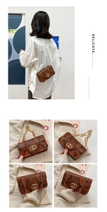 Detail of brown snakeskin pattern and gold double-ring hardware on a mini crossbody bag