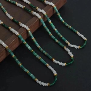 Detail shot of bohemian beaded necklace with green agates and white flat beads