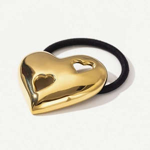 Close-up of heart-shaped 18k gold stainless steel charm on black elastic hair tie