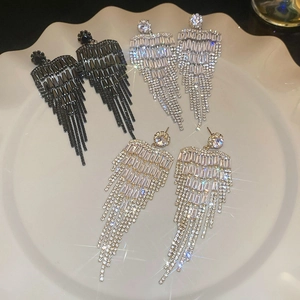 Detail view of long tassel earrings in black, silver, and gold with sparkling crystals