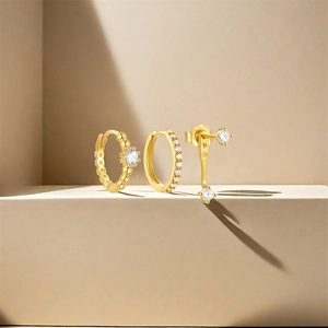 Macro shot of S925 silver gold-plated hoop earrings and studs set with white zircon