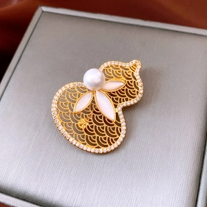 Macro shot of 18K gold plated pearl gourd brooch with filigree and shell petals