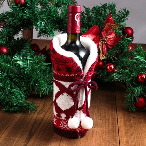 Knitted Christmas wine bottle cover with red reindeer pattern and white pom-poms