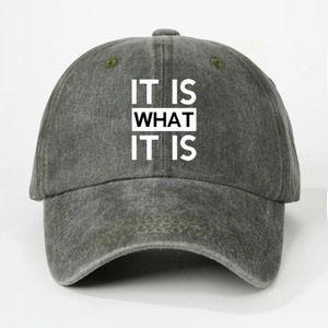 Detailed close-up of charcoal gray washed canvas cap with IT IS WHAT IT IS print