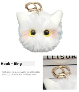 Close-up of fluffy white cat plush keychain featuring golden lobster clasp and soft fur texture