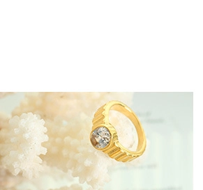 Gros plan d'une bague plaquée or 18 carats avec rainures verticales et zircon rond