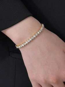 Close-up of sparkling gold plated tennis bracelet with zircons on a model wrist