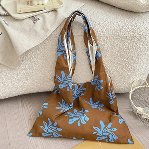 Detail of brown floral canvas tote bag with light blue prints and soft cotton texture