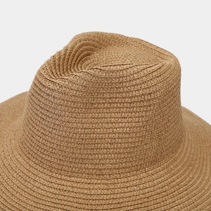 Close-up of a retro straw cowboy hat showing the fine woven texture and light brown fiber