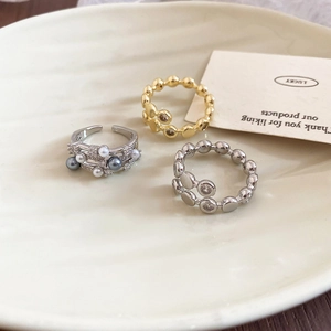 Three-piece set of layered rings featuring pearls and zircon on elegant ceramic tray