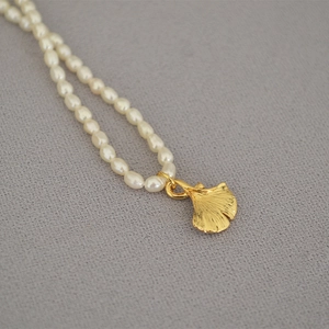Elegant freshwater pearl necklace with a golden ginkgo leaf pendant in a retro style