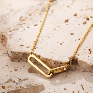 Minimalist 18K gold Mobius double ring necklace with zircon pendant on stone background