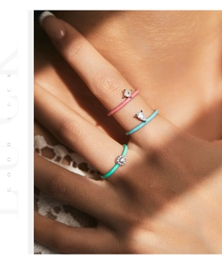Close-up of three colorful drip glaze rings with water drop zircon stacked on a finger