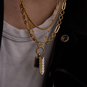 Detail of layered gold titanium necklace with blue lapis lazuli and fishbone pendant