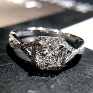Détail macro d'une bague diamant taille coussin avec anneau torsadé et pavage brillant