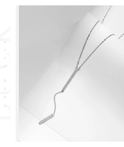 Macro detail of silver Y-shaped necklace with long pendants and white cubic zirconia