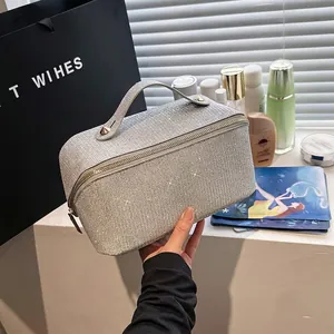Glittery silver makeup bag with handle and zipper shown in a lifestyle cosmetic setting